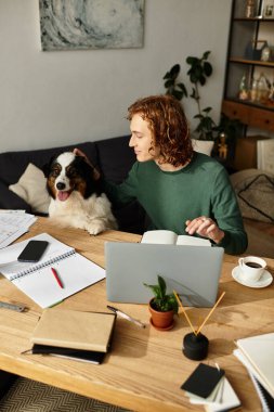 Genç adam rahat bir evde ders çalışırken köpeğiyle kaliteli vakit geçirmekten hoşlanıyor..