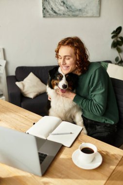 Genç bir adam evinde iç açıcı bir öğleden sonranın keyfini çıkarıyor. Etrafı konforla çevriliyken köpeğine sarılıyor..
