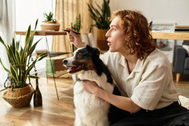 Genç bir adam yeşil ve sıcaklıkla çevrili köpeğiyle evde kaliteli vakit geçirmekten hoşlanır..