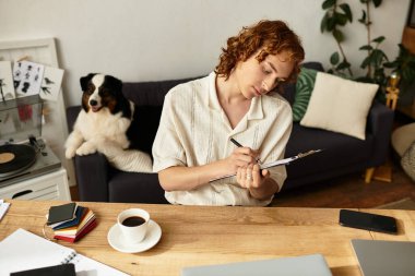 Genç bir adam evde notlar yazıyor, kahveden ve köpek arkadaşlığından zevk alıyor..