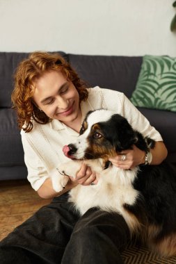 Genç bir adam sıcak bir yerde sevgi dolu köpeğiyle vakit geçirmekten zevk alır..
