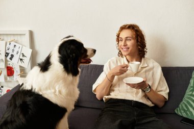 Parlak ve davetkar bir atmosfer. Genç bir adam kanepede rahatlıyor ve köpeğiyle bağ kuruyor..