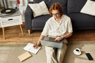 Sıcak atmosfer, güneşli bir günde evde çalışan ve ilham veren genç bir adamı yakalıyor..