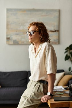 Rahat bir genç adam sıcak ve davetkar bir şekilde masaya yaslanır..