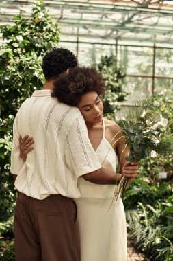 Sevgi dolu bir çift canlı bitkilerin arasında kucaklaşır ve serada birbirlerine olan bağlarını kutlarlar..