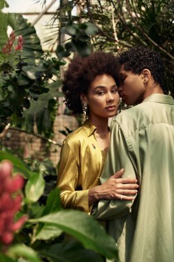 Sevgi dolu bir çift yemyeşil çiçeklerle dolu huzurlu bir serada kucaklaşır..