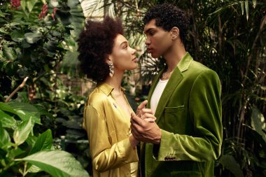 Huzurlu bir serada, genç bir çift canlı bitkiler arasında hassas bir anı paylaşıyor..