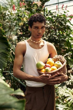 Genç ve şık bir adam, etrafını saran yemyeşil çiçeklerle, sevgi ve mutluluk saçarak vakit geçirir..