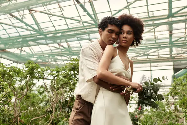 Genç bir çift yemyeşil bir ortamda sarılıyor, sevgi ve sükunet yayıyor..