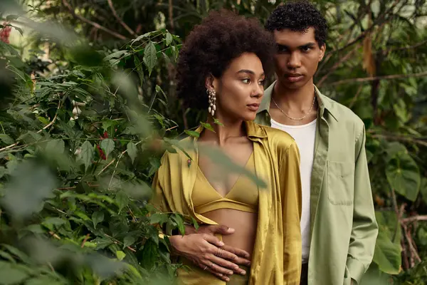 İki genç aşık, canlı bitkiler ve yeşilliklerle çevrili samimi bir anı paylaşıyor..