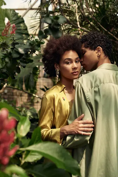 Sevgi dolu bir çift yemyeşil çiçeklerle dolu huzurlu bir serada kucaklaşır..