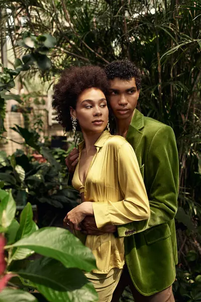 Sevgi dolu çift, sera atmosferindeki zengin bitkilerle çevrili hassas bir anı paylaşıyor..