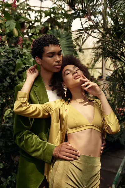 Genç bir çift, canlı bitkiler ve yeşillikler arasında şefkatle kucaklaşırken aşk yeşerir..