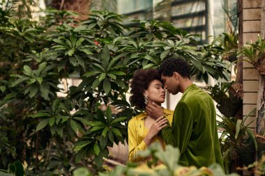 Birbirini seven çiftler yemyeşil ve yemyeşil dolu canlı bir serada kucaklaşır..