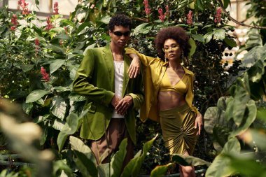 Genç bir çift, doğayla çevrili, yemyeşil bir serada sevgiyle kucaklaşır..