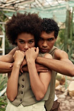 Genç bir çift yeşilliklerle çevrili serada hassas bir anı paylaşıyor..