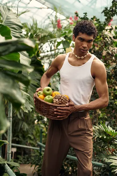 Genç ve şık bir adam, sakin bir seradaki canlı bitkilere bakarken doğayla olan bağını bağrına basar..