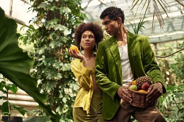 Birbirini seven bir çift, canlı bitkiler ve meyveler arasında birbirine eşlik eder..