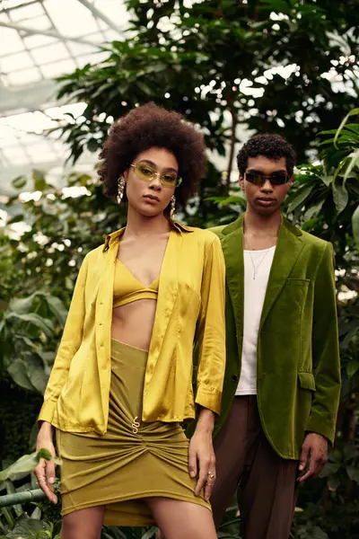 Sevgi dolu bir çift, güzel bir seradaki canlı bitkilerin arasında hassas bir anı paylaşıyor..