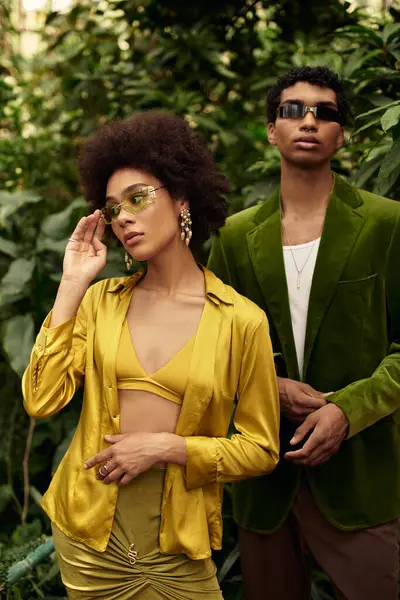 Genç çift yemyeşil çiçeklerle dolu bir serada kucaklaşıyor, birlikte sevgi ve neşe saçıyorlar..