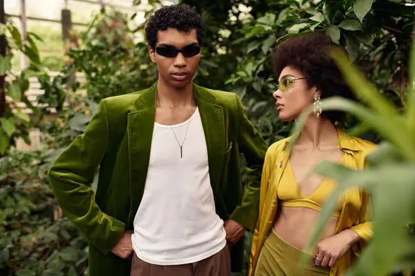 Sevgi dolu bir çift, yemyeşil bitkiler ve romantizmle çevrili bir serada duruyor..