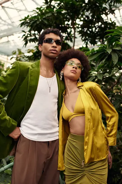 Genç bir çift yemyeşil bitkilerin arasında sarılıyor, sevgilerini ve neşelerini gösteriyor..