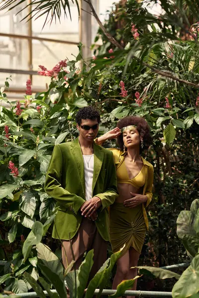 Canlı bir serada, bir çift, gelişmekte olan bitki ve çiçeklerin arasında özel bir anı paylaşır..