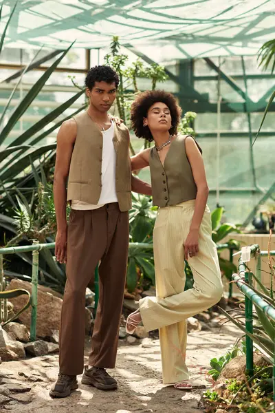 Sevgi dolu bir çift, çeşitli bitkiler ve sükunetle çevrili, yemyeşil bir serada bir anı paylaşır..