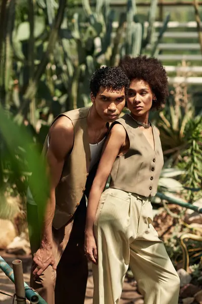 Genç bir çift, aşklarını ve bağlantılarını gösteren, yemyeşil bitkilerle nazikçe kucaklaşır..