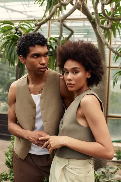 Genç bir çift yemyeşil bir serada duruyor, sera arasında sevgi yayıyorlar..