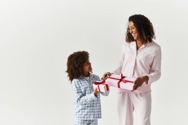 Stüdyo: Pijamalı siyahi anne ve kızı hediye alışverişi.