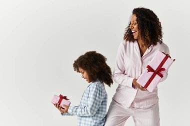 Mutlu Afro-Amerikan annesi ve kızı hediyelerle pijamalarıyla.