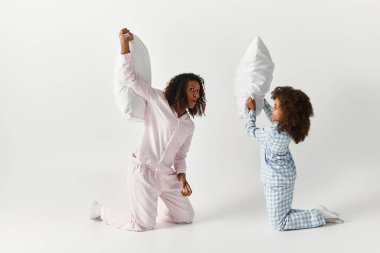 Siyah anne ve kızı pijama yastığıyla gride kavga ediyor..