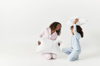 Siyah anne ve çocuk pijamalarıyla stüdyoda kavga ediyorlar.