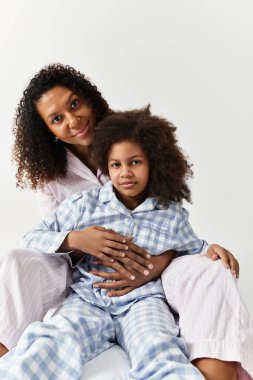 Güzel bir Afrikalı Amerikalı anne kızına sarılıyor..