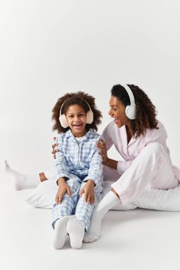 Eşleşen pijamalar, anne ve kız şarkı söyler, güler ve müziği paylaşır.