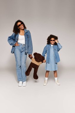 Siyah anne ve kız kot, gri stüdyo.