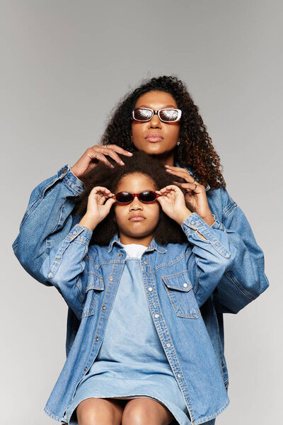 Matching denim, mother and daughters stylish love in studio.