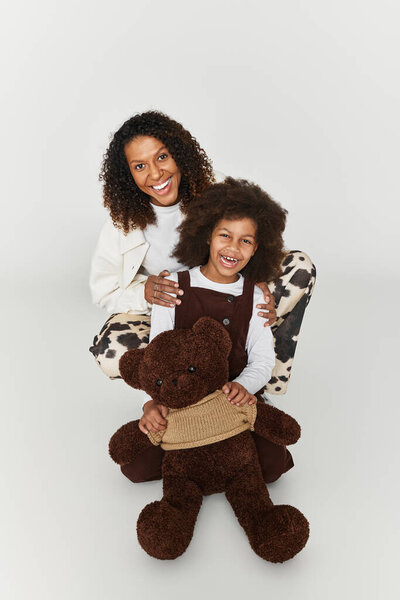 Дуэт матери и дочери демонстрирует свои стильные наряды, разделяя радостный момент вместе.