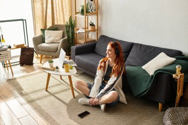 Genç ve güzel bir kadın evde dinlenirken kendini müziğe kaptırmış bir şekilde yerde bağdaş kurarak oturur..