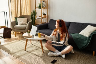 Genç kadın bacak bacak üstüne atmış, çay yudumlarken parlak, şık bir odada müzik dinliyor..