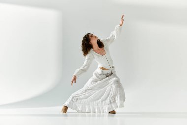 Genç bir kadın zarif bir dans sergiliyor dalgalı beyaz bir elbise içinde, zarafet ve tarz yayıyor..