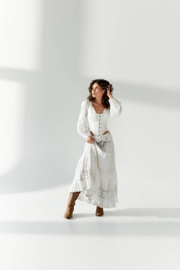 Genç ve güzel bir kadın beyaz bir elbise içinde modern moda eğilimleri sergiliyor..