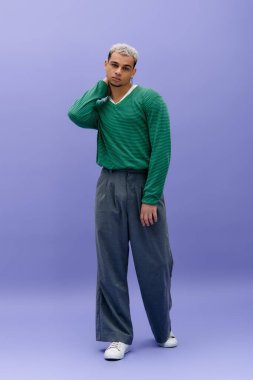 Genç bir Afrikalı Amerikalı, kendine güvenen bir şekilde poz verirken şık bir kıyafet sergiliyor..