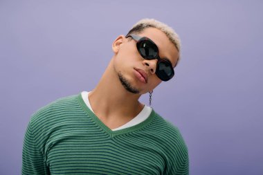 Genç Afrikalı Amerikalı bir adam moda anlayışını boyalı saçları ve modaya uygun kıyafetleriyle sergiliyor..