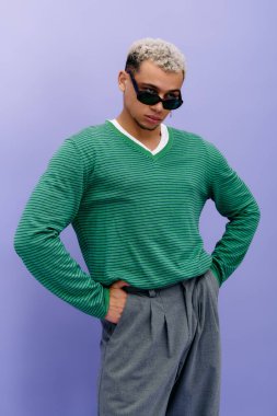 Saçları boyalı genç bir Afro-Amerikalı kendine güvenen şık bir elbise içinde poz veriyor..