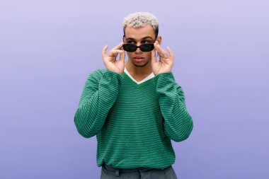 Genç bir Afro-Amerikan erkeği poz verirken eşsiz tarzını sergiliyor..