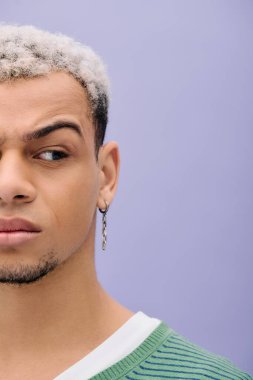 Saçları boyalı genç siyah bir adam kendine güvenen şık bir elbise içinde, çeşitliliği kucaklayan bir poz verir..