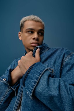 Genç bir Afrikalı Amerikalı moda anlayışını şık bir kot ceketle sergiliyor..