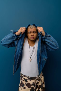 Genç Afrikalı Amerikalı bir adam, kot giymiş, boyalı saçlarıyla eşsiz tarzını sergiliyor..